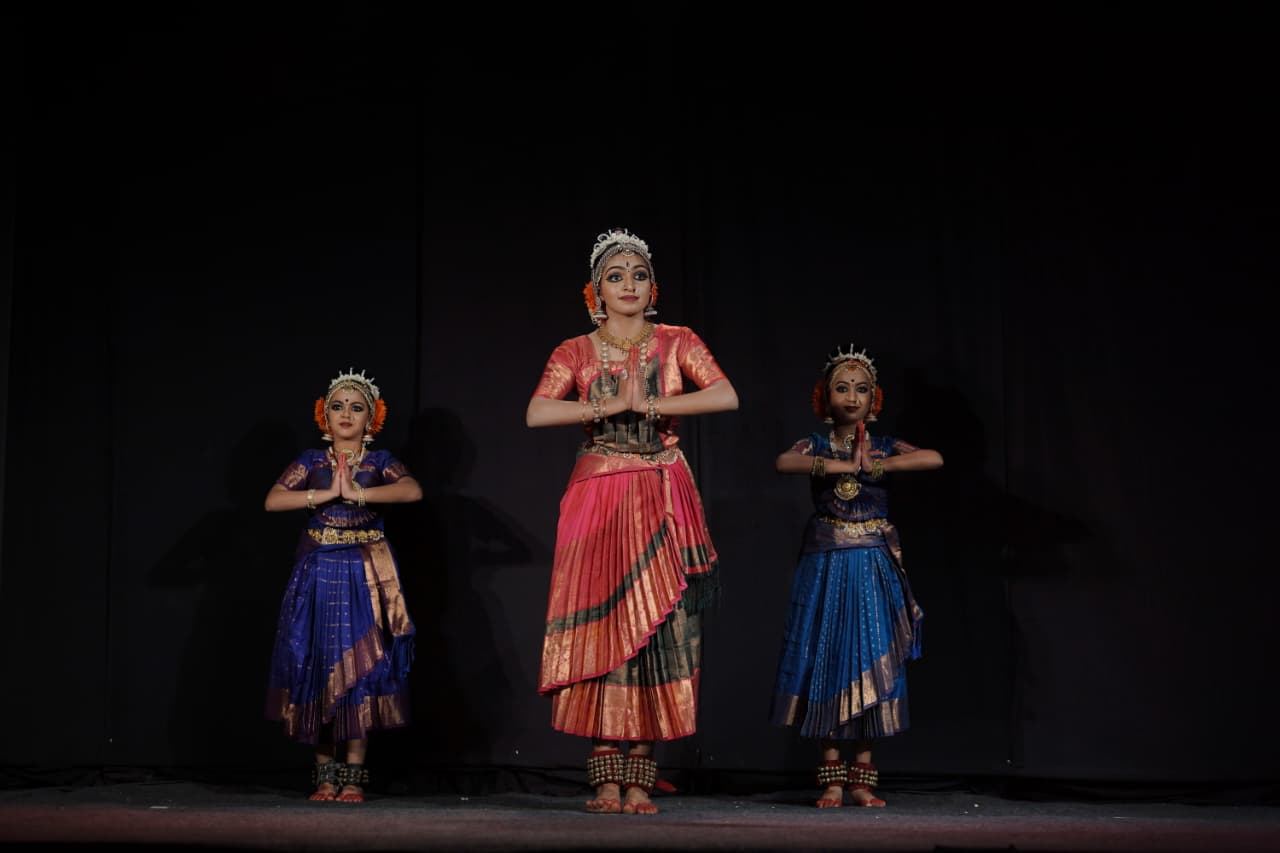 Three Nrithyoham dancers moving together at AIDA Kochi Fest