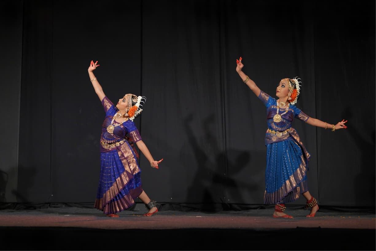 Two classical dancers extending expressive hand gestures
